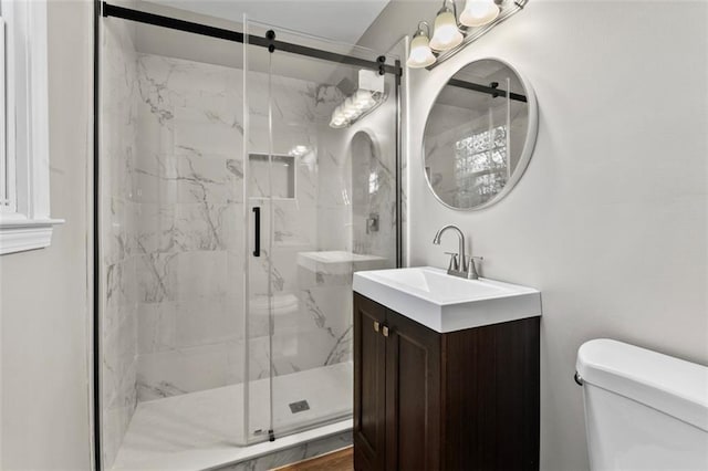 bathroom featuring vanity, toilet, and an enclosed shower