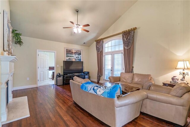 living area with baseboards, dark wood finished floors, ceiling fan, and a fireplace