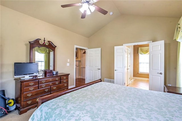 bedroom with ceiling fan, visible vents, multiple windows, and vaulted ceiling