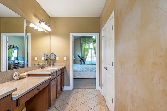 ensuite bathroom featuring vanity, ensuite bathroom, baseboards, and tile patterned flooring