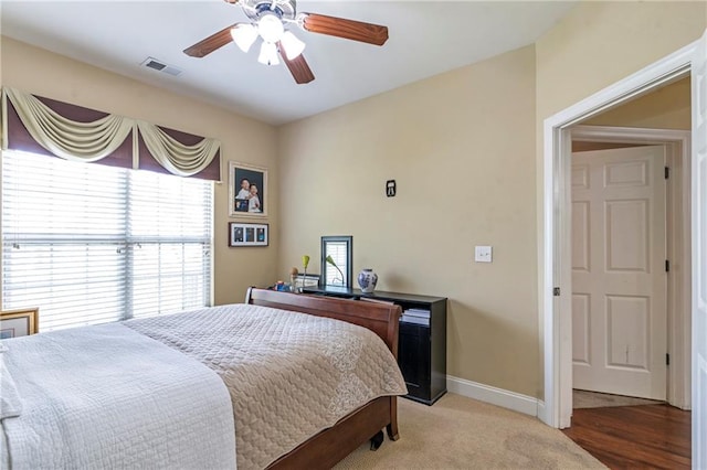 bedroom with baseboards, ceiling fan, light carpet, and visible vents