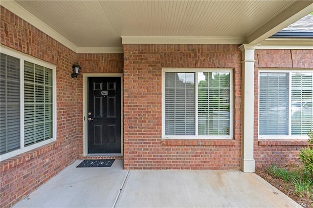 view of exterior entry featuring brick siding