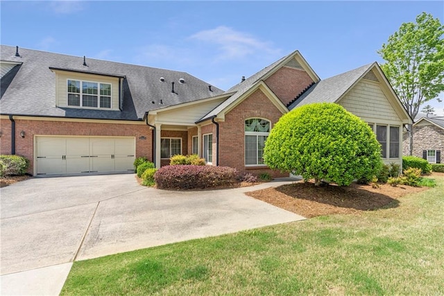 view of front of house featuring brick siding, driveway, roof with shingles, and a garage