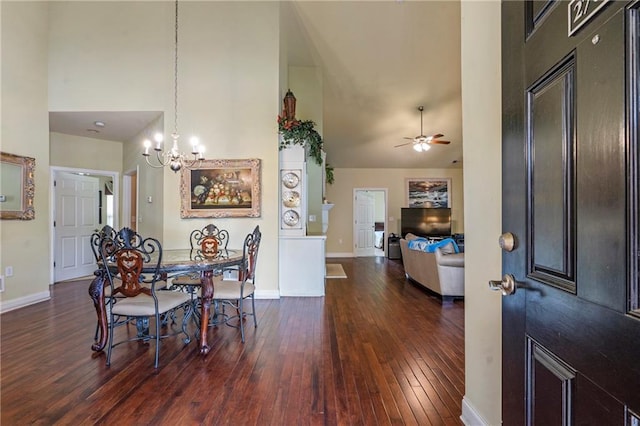 foyer with dark wood-type flooring, baseboards, a towering ceiling, and ceiling fan with notable chandelier