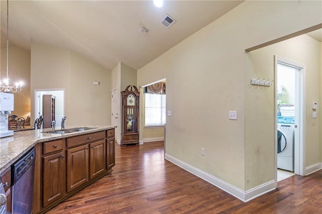 kitchen featuring dark wood-style flooring, dishwasher, washer / clothes dryer, vaulted ceiling, and visible vents