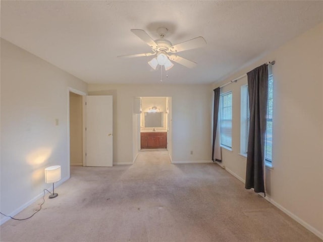 unfurnished room featuring light colored carpet, ceiling fan, and baseboards