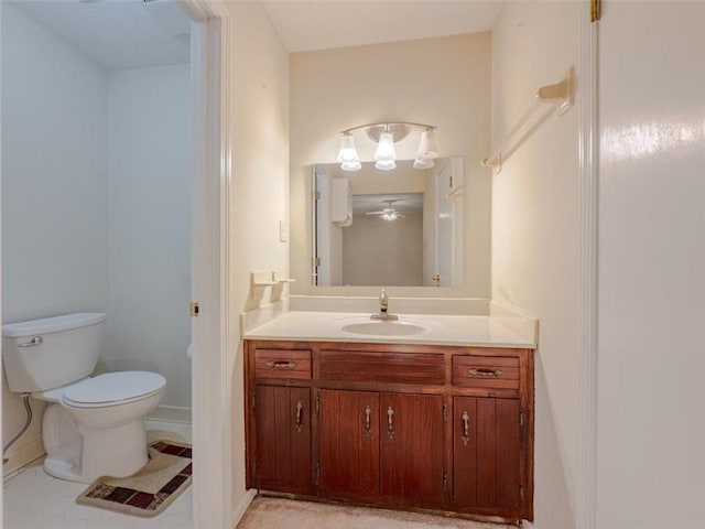 bathroom with toilet, vanity, and baseboards