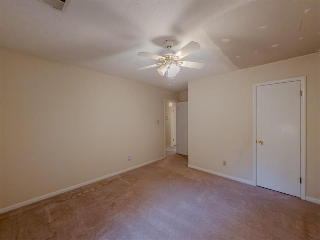 empty room with carpet flooring, ceiling fan, and baseboards