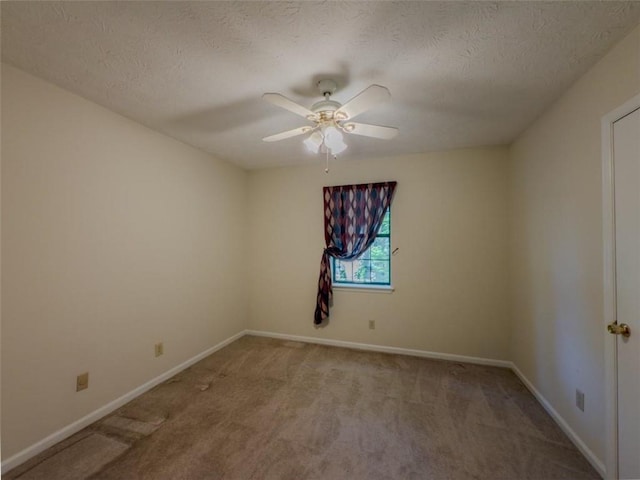 spare room with light carpet, a ceiling fan, baseboards, and a textured ceiling