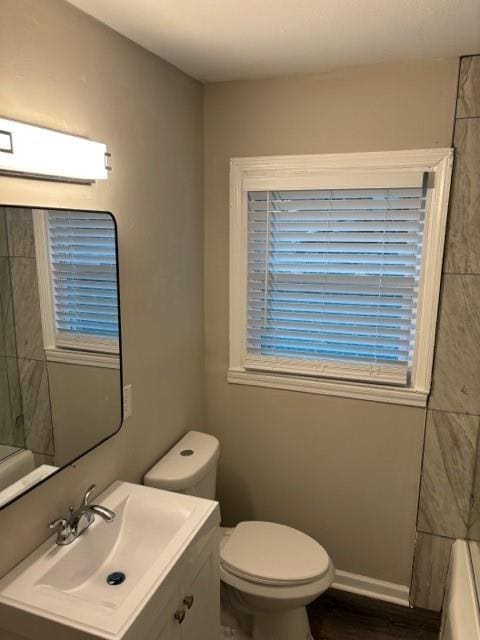 bathroom featuring a wall mounted air conditioner, vanity, and toilet