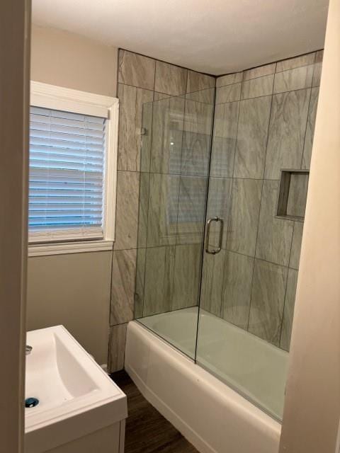 bathroom featuring combined bath / shower with glass door, hardwood / wood-style floors, and vanity