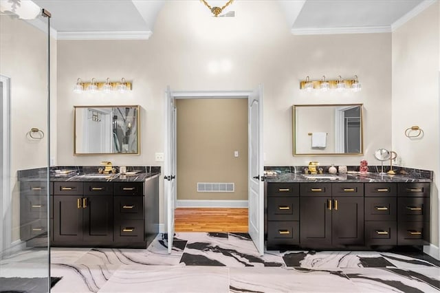 4670 Hamden Forest Dr SW, Atlanta, GA 30331 - bathroom with crown molding, two vanities, baseboards, and wood finished floors