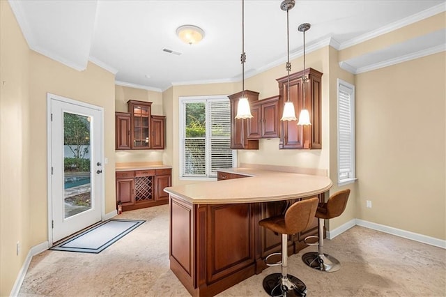 4670 Hamden Forest Dr SW, Atlanta, GA 30331 - kitchen with baseboards, a peninsula, a breakfast bar, brown cabinets, and pendant lighting