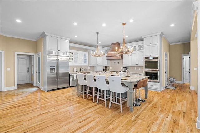 4670 Hamden Forest Dr SW, Atlanta, GA 30331 - kitchen with appliances with stainless steel finishes, a chandelier, custom exhaust hood, crown molding, and a kitchen breakfast bar