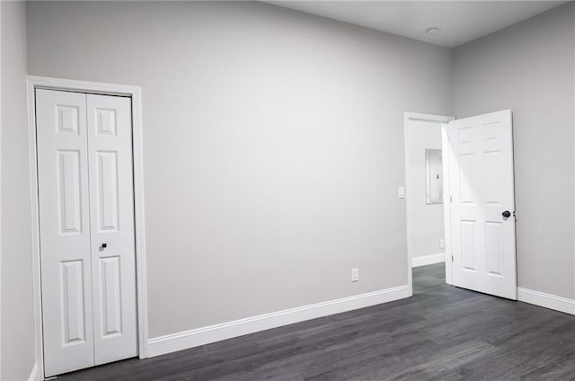 1156 Clinton Rd, Macon, GA 31211 - unfurnished bedroom featuring baseboards, dark wood-style floors, electric panel, and a closet