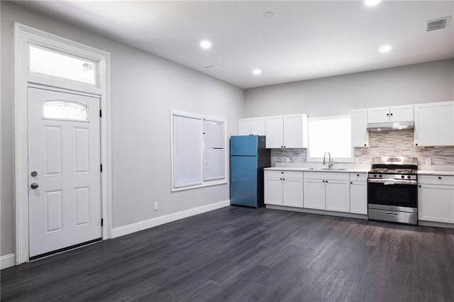 1156 Clinton Rd, Macon, GA 31211 - kitchen with freestanding refrigerator, stainless steel gas range, under cabinet range hood, a sink, and light countertops