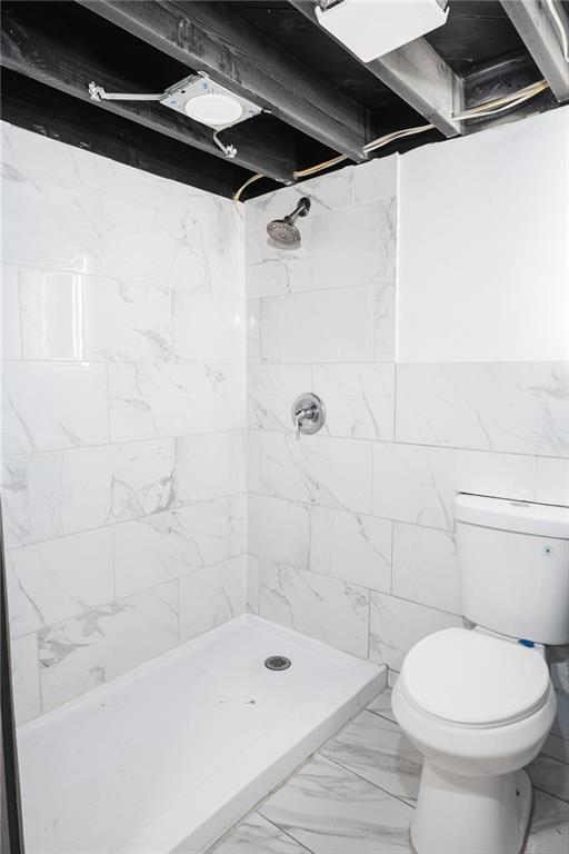 1156 Clinton Rd, Macon, GA 31211 - bathroom with toilet, a shower stall, marble look tile flooring, and tile walls