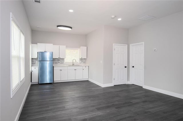 1156 Clinton Rd, Macon, GA 31211 - kitchen with freestanding refrigerator, a sink, light countertops, white cabinets, and baseboards