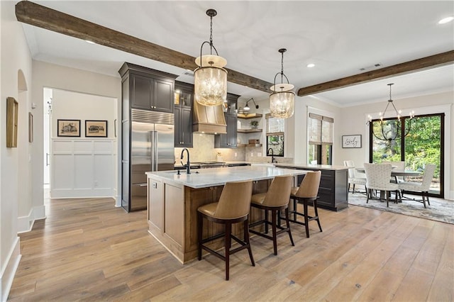 284 Hook St, Alpharetta, GA 30009 - kitchen with built in fridge, open shelves, light countertops, light wood finished floors, and beam ceiling