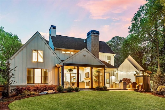 284 Hook St, Alpharetta, GA 30009 - back of house at dusk with a chimney, board and batten siding, and a lawn