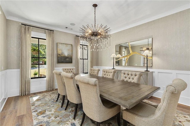 284 Hook St, Alpharetta, GA 30009 - dining area with a chandelier, wood finished floors, a wainscoted wall, crown molding, and a decorative wall