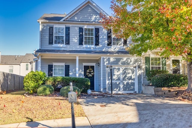 view of front of property with driveway, a garage, and fence