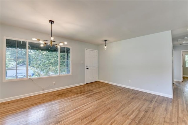 3991 Adamsville Dr SW, Atlanta, GA 30331 - empty room featuring light wood-type flooring and a chandelier