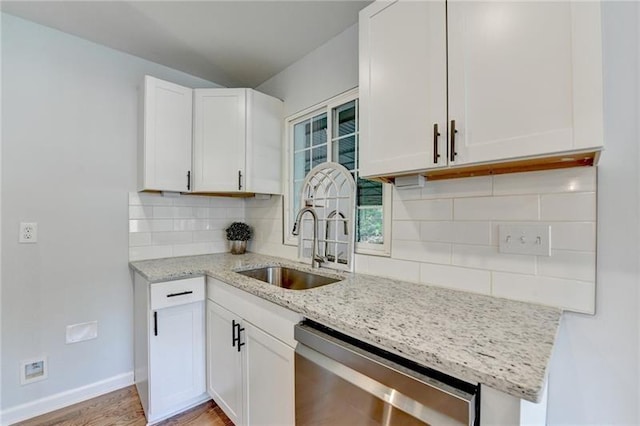 3991 Adamsville Dr SW, Atlanta, GA 30331 - kitchen featuring stainless steel dishwasher, light stone counters, backsplash, and white cabinetry