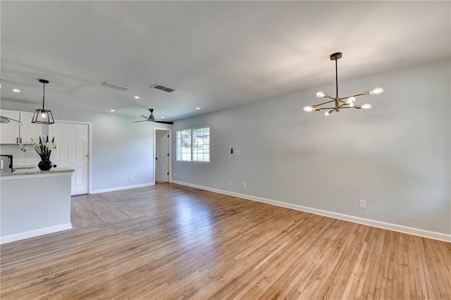 3991 Adamsville Dr SW, Atlanta, GA 30331 - unfurnished living room featuring light wood finished floors, a chandelier, ceiling fan, and recessed lighting