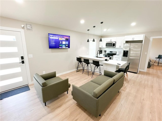 living room featuring sink and light wood-type flooring