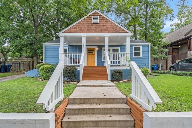 bungalow-style home featuring a porch, a front yard, and stairs