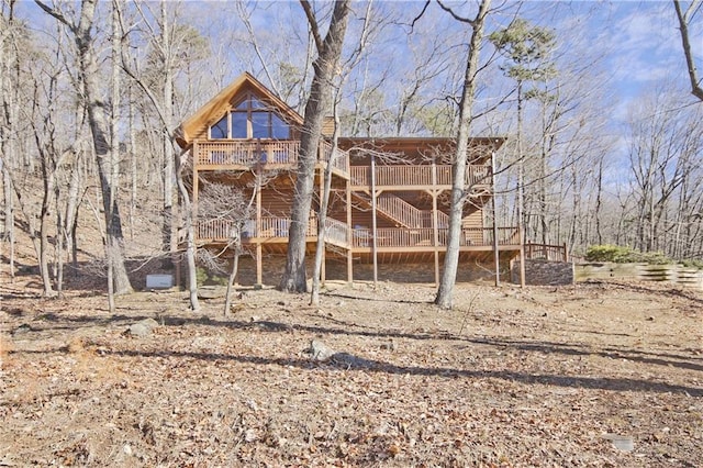 back of property with a deck and stairway