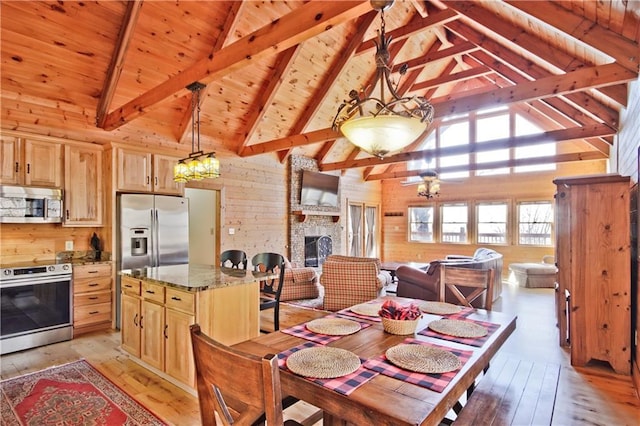 dining area featuring wooden ceiling, wood walls, a fireplace, beam ceiling, and light wood finished floors