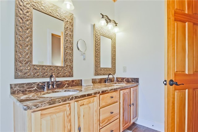 full bathroom with a sink, baseboards, and double vanity