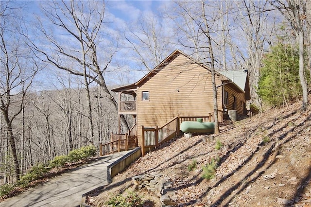 view of side of property featuring a balcony and heating fuel