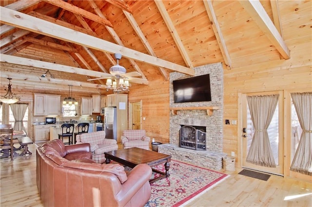 living area with light wood-style floors, a fireplace, wooden ceiling, and wooden walls