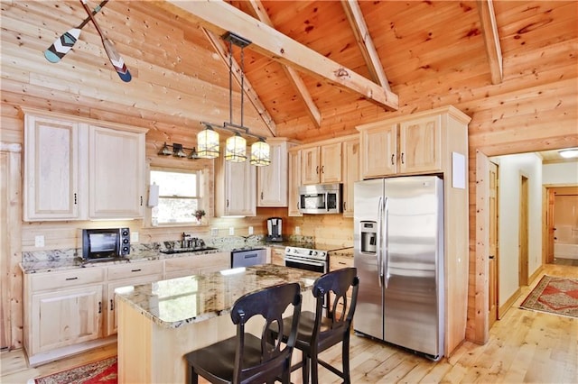 kitchen with vaulted ceiling with beams, light stone counters, light wood-style flooring, wood ceiling, and appliances with stainless steel finishes