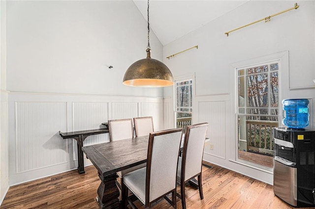 dining space with vaulted ceiling and wood-type flooring