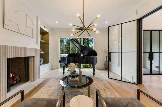 miscellaneous room with a chandelier and light hardwood / wood-style flooring