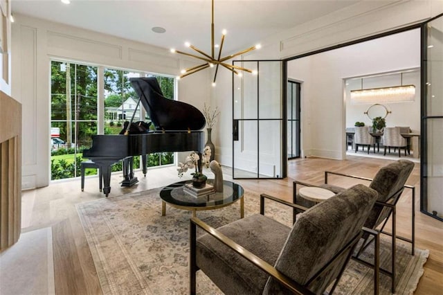 sitting room with an inviting chandelier and light hardwood / wood-style flooring