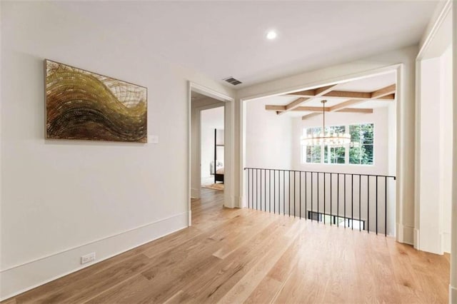 unfurnished room featuring beamed ceiling and wood-type flooring