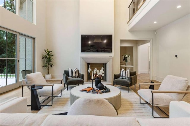 living room with plenty of natural light, french doors, a high ceiling, and light hardwood / wood-style flooring