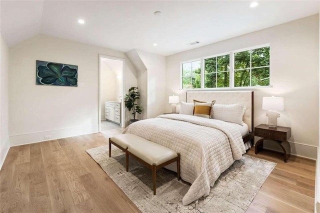 bedroom with vaulted ceiling and light wood-type flooring