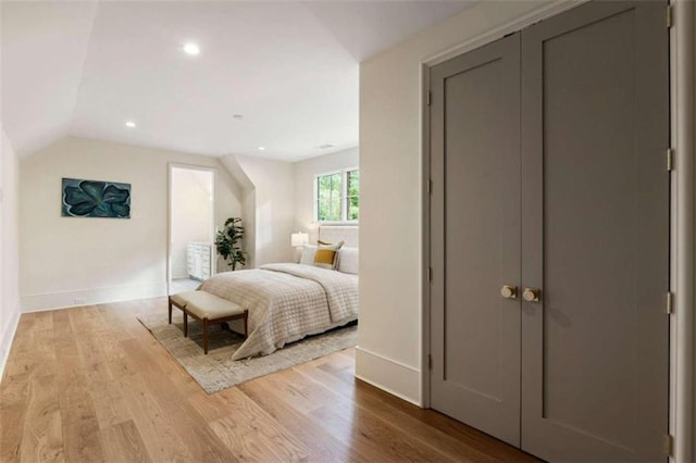 bedroom featuring light hardwood / wood-style flooring and lofted ceiling