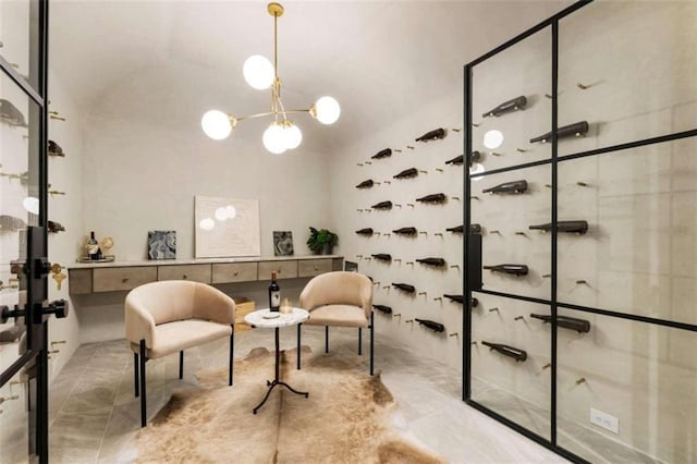 wine area featuring tile patterned floors, vaulted ceiling, and an inviting chandelier