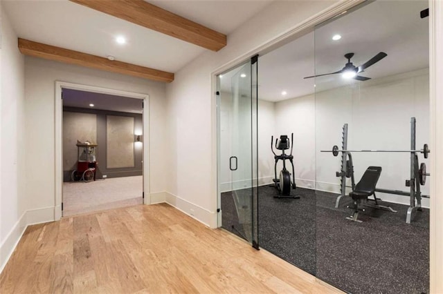 workout room with ceiling fan and light hardwood / wood-style flooring