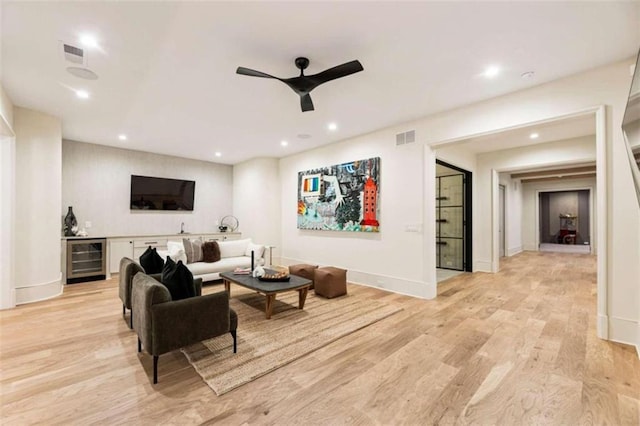 living room featuring bar, wine cooler, ceiling fan, and light hardwood / wood-style floors