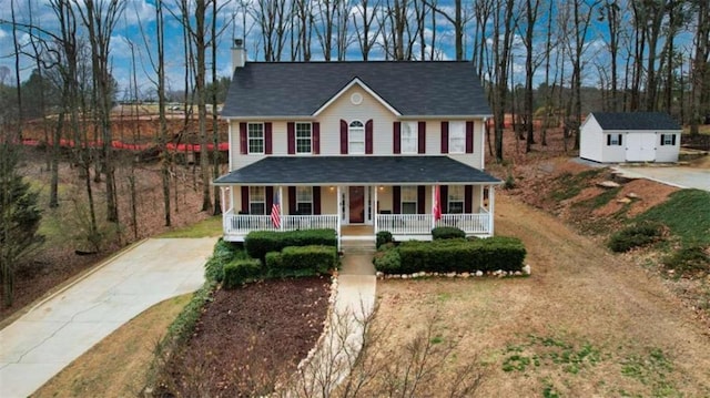 view of front of property featuring covered porch, a chimney, and an outdoor structure