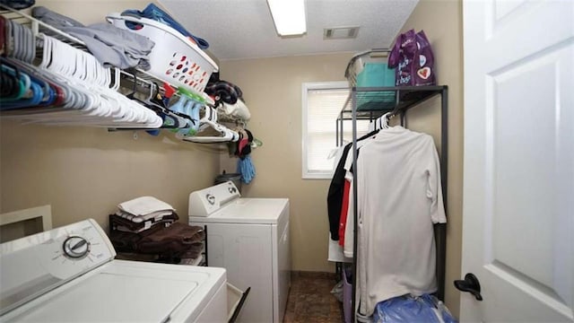 laundry area with laundry area, a textured ceiling, visible vents, and washer and dryer