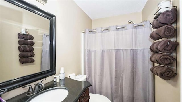 full bathroom featuring toilet, a shower with shower curtain, and vanity